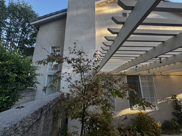 The existing chimney rising past the roofline next to the patio cover
