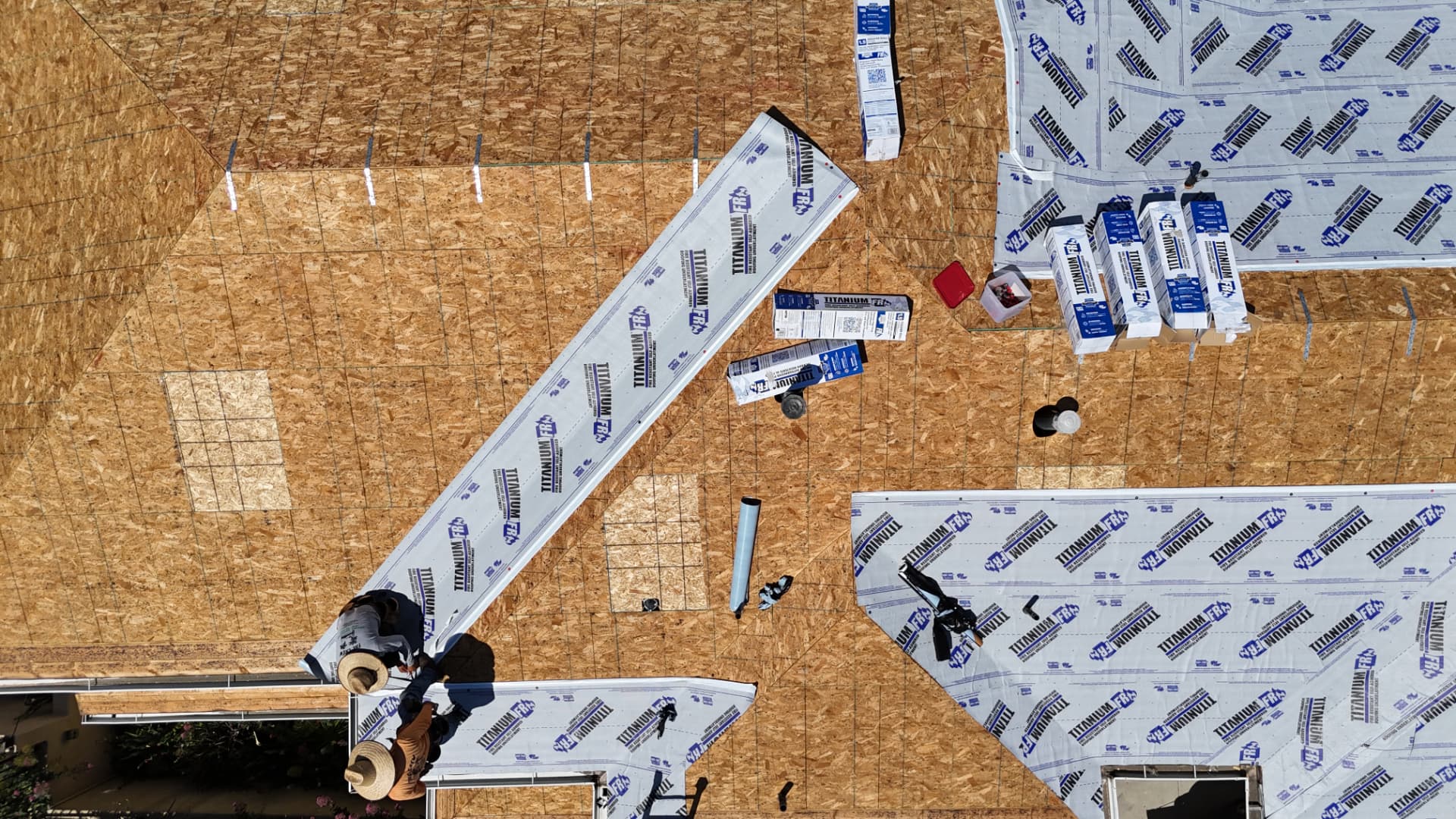 GreenCal crew installing Titanium FR underlayment over a full roof deck