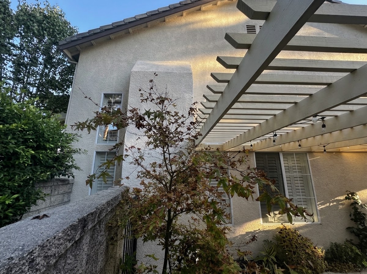 A stucco chase with a sloped cap that tapers back into the wall