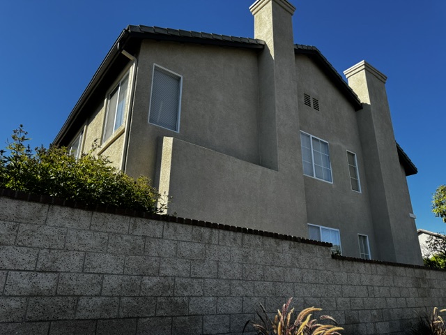 Side elevation of the home showing the concrete tile roof and two stucco chimney chases
